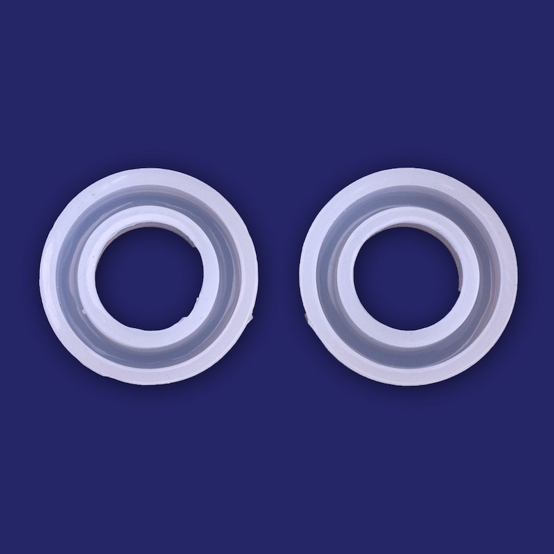 May include: Two white silicone rings, each with a smaller inner ring, are shown against a blue background.