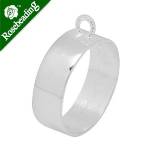 Puede incluir: Anillo de metal plateado con un bucle en la parte superior. El anillo tiene un diámetro de aproximadamente 2,5 cm y un acabado liso y pulido.