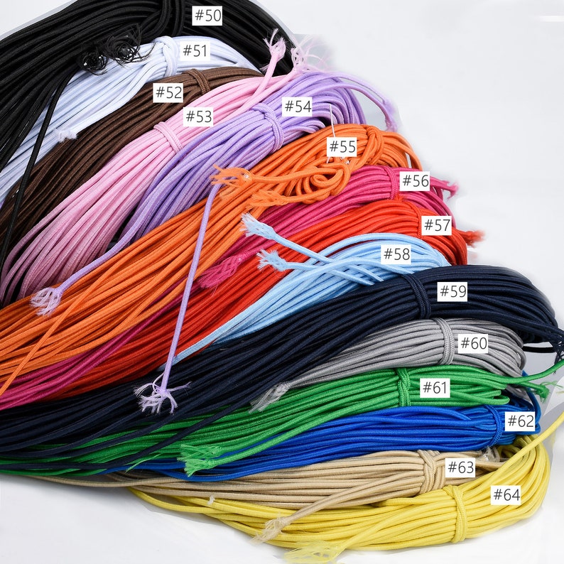 May include: A collection of 15 different colours of elastic cord, numbered #50 through #64. The cords are arranged in a fan shape, with the darkest colour at the top and the lightest colour at the bottom.