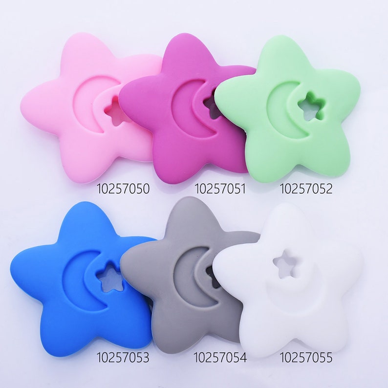 May include: Six silicone star-shaped teethers in different colors: pink, purple, green, blue, gray, and white. Each teether has a crescent moon and a star cutout.