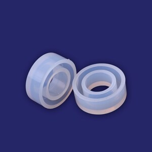May include: Two clear silicone rings, one slightly larger than the other, with a smooth, glossy finish. The rings are stacked on top of each other.