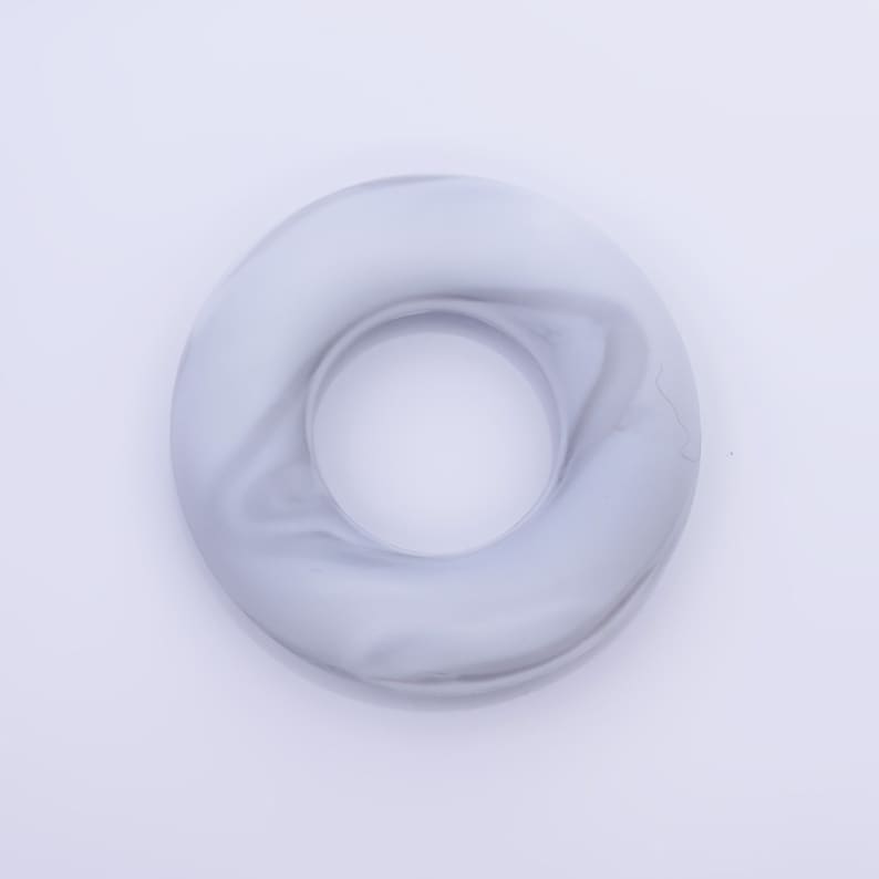 May include: A white and gray marble ring with a smooth, glossy finish.