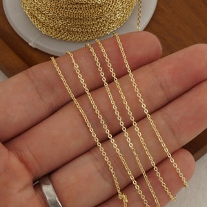 May include: Gold chain in various lengths, displayed on a hand. The chain is a delicate, fine link style.