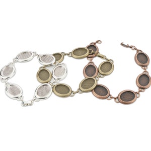 May include: Three oval-shaped metal bracelets with a mesh design. The bracelets are silver, bronze, and copper in color.