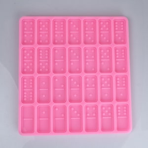 May include: Pink silicone mold with 28 individual domino-shaped cavities.
