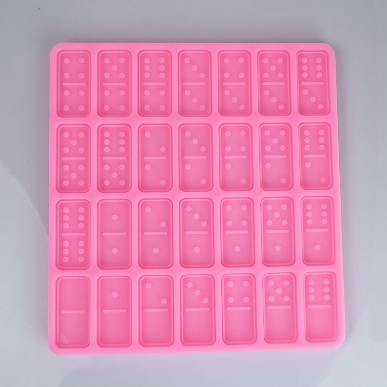 May include: Pink silicone mold with 28 individual domino-shaped cavities.