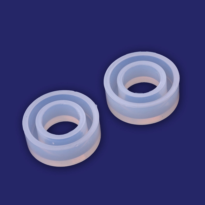 May include: Two clear silicone ring molds, one slightly larger than the other. The molds are designed to create rings with a smooth, polished finish.