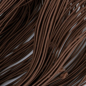 May include: A close-up of a bundle of brown elastic cord. The cord is smooth and has a slight sheen.