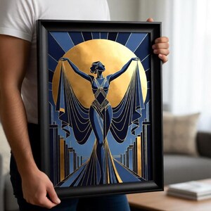 A man is holding a framed artwork featuring an abstract design with a woman and a large sun-like element.