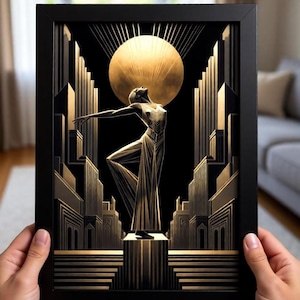 A person is holding up a framed artwork depicting an Art Deco-style scene with a stylized figure in the center, surrounded by architectural elements and a large sun-like object.
