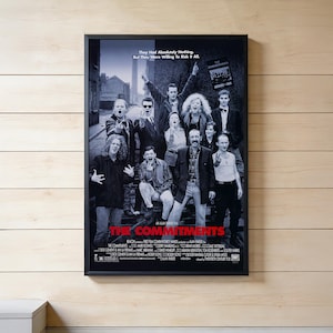 May include: A framed black and white movie poster for "The Commitments" featuring a group of people. The poster has the movie title in red and the text "They Had Absolutely Nothing, But They Were Willing To Risk It All."