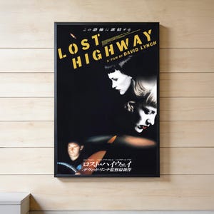 Könnte beinhalten: Ein gerahmtes Filmplakat für Lost Highway, ein Film von David Lynch. Das Plakat zeigt einen schwarzen Hintergrund mit fettem gelbem Text, ein kontrastreiches Porträt einer Person mit dunklem Haar und ein Bild einer Person am Steuer.