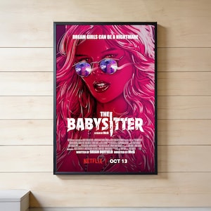 Op de afbeelding: Een ingelijste filmposter voor The Babysitter met een gestileerde illustratie van een persoon met lang roze haar en een ronde zonnebril. De tekst luidt DREAM GIRLS CAN BE A NIGHTMARE, THE BABYSITTER, A FILM BY MCG, NETFLIX en OCT 13.