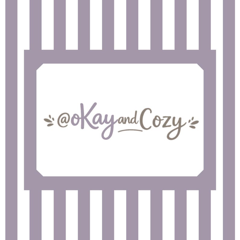 May include: A white background with a lavender frame and vertical stripes. The text "@Kay and Cozy" is written in a script font within the frame. The text is in shades of lavender and brown.