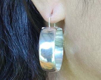 clean, simple hoop earrings. hand crafted from recycled sterling silver. Very lightweight 1/2" wide, 1 1/2" diameter.