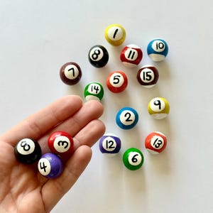 May include: A set of three ceramic nesting bowls in graduating sizes. The bowls are white with a speckled, textured finish and feature a slightly flared rim. The largest bowl measures approximately 8 inches in diameter.