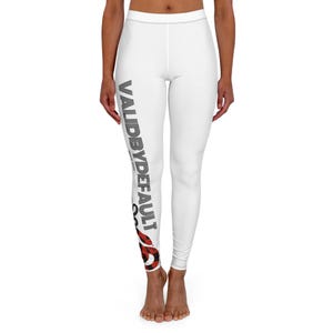 May include: White leggings featuring a vertical black and white striped text graphic that reads VALIDBYDEFAULT, with the smaller text "since 2005" underneath, and a red and black buffalo plaid pattern graphic at the bottom of the right leg.