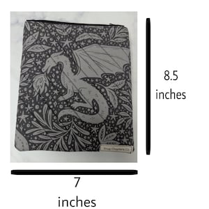 Op de afbeelding: Een donkergrijs tasje met rits voorzien van een lichtgrijs patroon van een draak, sterren en bladeren. Het tasje heeft diagonale doorgestikte naden en een klein label met Snug Chapters Co. Het is 21,59 cm hoog en 17,78 cm breed.