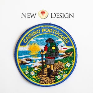 May include: Embroidered patch with a blue border and the words "CAMINO PORTUGUÊS". The patch features a hiker with a backpack walking along a coastal path, with a sunrise over the ocean. The words "NEW DESIGN" are above the patch.