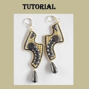 Könnte beinhalten: Ein Paar schwarze und goldene Perlenohrringe in Form eines Blitzes. Die Ohrringe sind aus kleinen Perlen gefertigt und haben einen schwarzen Hämatit-Tropfen am unteren Ende. Die Ohrringe heißen "Sand Earring Bead Embroidery Tutorial" und wurden von "Éva Csizmadia / Vicusdesign" entworfen.