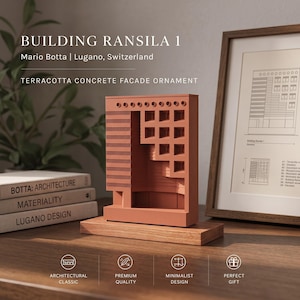 May include: A terracotta-colored concrete facade ornament of Building Ransila 1 by Mario Botta in Lugano, Switzerland. The rectangular architectural model features a grid of square windows and a flat base, displayed on a wooden stand.