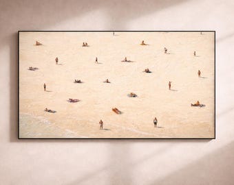 Könnte beinhalten: Gerahmter Kunstdruck, der eine Strandszene mit zahlreichen kleinen Figuren am Strand zeigt. Einige sonnen sich, andere stehen oder gehen am Wasser. Das Kunstwerk ist mit einem schwarzen Rahmen versehen.