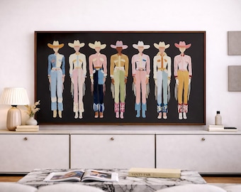May include: A framed artwork featuring stylized figures in cowboy attire. Each figure is depicted in a unique color palette, including pink, blue, and yellow, with cowboy hats and fringed accents. The artwork hangs above a white cabinet.
