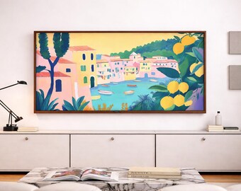 Könnte beinhalten: Ein gerahmter Kunstdruck, der eine Küstenlandschaft mit farbenfrohen Gebäuden, Booten und Zitronen zeigt. Das Kunstwerk ist an einer weißen Wand über einem weißen Schrank angebracht. Eine schwarze Schreibtischlampe und ein Marmor-Couchtisch befinden sich im Vordergrund.