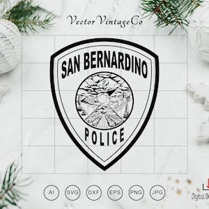 Puede incluir: Diseño en blanco y negro de la insignia de la policía de San Bernardino. El emblema en forma de escudo presenta las palabras "SAN BERNARDINO POLICE" y una ilustración detallada de un paisaje con montañas, una carretera y edificios.