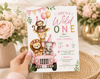 May include: A birthday invitation card featuring a pink jeep carrying a cartoon monkey, giraffe, lion, and elephant wearing party hats. The text reads: Lucy is a Wild One, Join us for a Wild Celebration, Saturday June 15th at 3:00 PM, The Safari Clubhouse, 12 Zoo Lane, Columbus, Ohio 12345, RSVP to Alicia 440-123-4567 by May 30th, Registered at Pottery Barn Kids & Amazon.