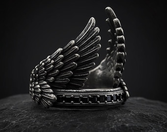 Anillo de ala de plata oscura oxidada con banda abierta de estilo gótico.