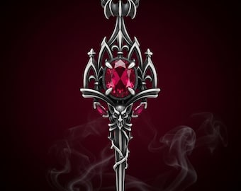 Colar com pingente de espada gótica com gema vermelha, brasão de morcego e motivo de caveira.