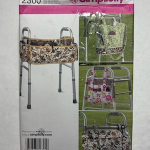 Op de afbeelding: Simplicity patroon 2300 voor rollatortassen. Het patroon toont verschillende rollatortasontwerpen in diverse bloemen- en patronenstoffen. De tassen worden aan het rollatorframe bevestigd en bieden opbergruimte. Het patroon bevat de tekst "ONE SIZE".