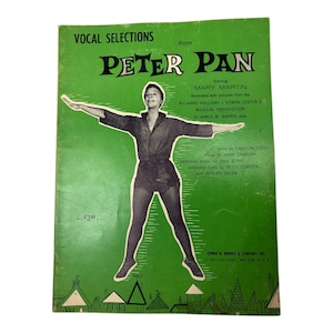May include: Vintage "Peter Pan" musical score book with a green cover. The cover features a black and white image of Mary Martin in costume with her arms outstretched. Text includes "Vocal Selections from Peter Pan".