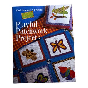 May include: A book titled Kari Pearson & Friends Playful Patchwork Projects featuring a cover with a colorful quilt design. The quilt displays various fabric squares with appliquéd insects including a grasshopper, bee, and butterflies.