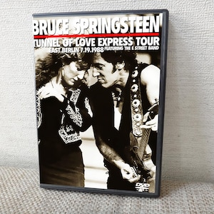 Puede incluir: Caja de DVD del concierto de Bruce Springsteen, Tunnel of Love Express Tour, en Berlín Oriental el 19 de julio de 1988, con The E Street Band. La portada muestra una imagen en blanco y negro de Springsteen con una mujer. La caja es de plástico gris.