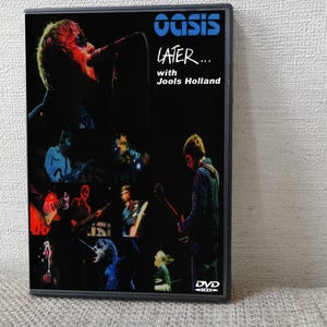 May include: A black DVD case featuring the Oasis band logo in blue at the top, with the text "LATER... with Jools Holland" below it. The cover displays a collage of various concert performance photographs in dark tones, and a DVD Video logo at the bottom.