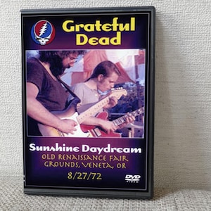 May include: DVD case featuring the Grateful Dead band. The cover has a photo of the band playing guitars, with the text "Sunshine Daydream" and the date "8/27/72". The DVD is labeled "DVD VIDEO".