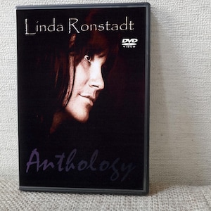 Könnte beinhalten: DVD-Hülle mit Linda Ronstadt. Das Cover ist überwiegend schwarz, mit einem Seitenprofil von Ronstadts Gesicht in der Mitte. Der Titel "Linda Ronstadt" steht oben, und "Anthology" ist in einer kursiven Schrift unten geschrieben. Das DVD-Logo ist sichtbar.