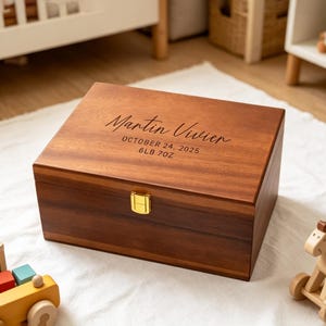 Puede incluir: Una caja rectangular de madera con tapa con bisagras y cierre dorado. La caja está grabada con el nombre "Martin Vivier", la fecha "24 de octubre de 2025" y el peso "2,9 kg". La caja es de madera marrón oscuro.