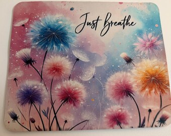 Peut inclure: Un tapis de souris carré avec un motif aquarelle de pissenlits aux tons bleus, roses et oranges sur un fond pastel. Les mots "Just Breathe" sont écrits en script élégant.