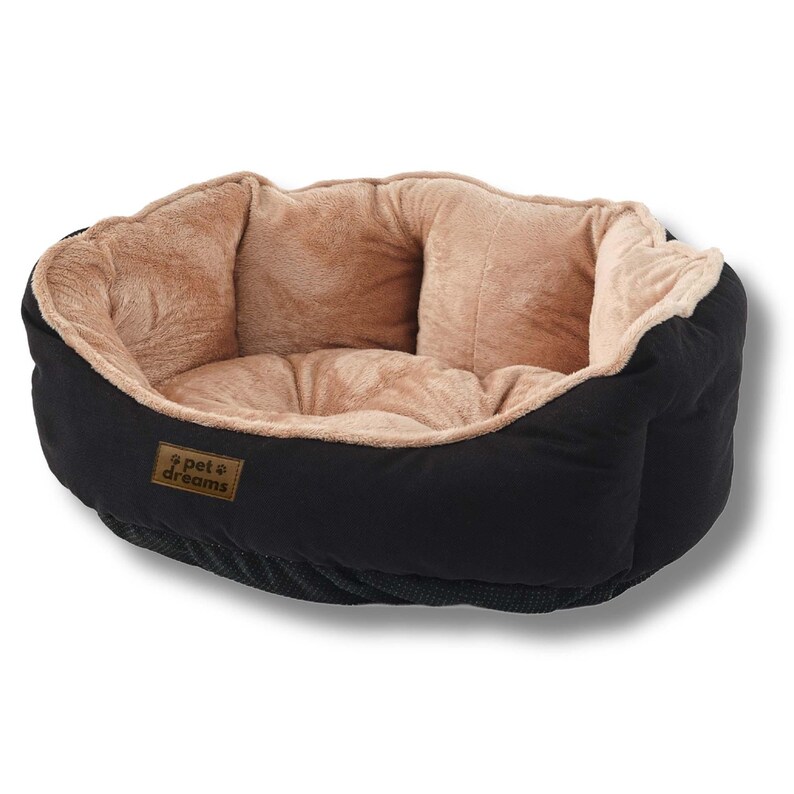 Op de afbeelding: Een zwart huisdierbed met een zacht, bruin interieur. Het bed heeft een afgeronde vorm en een laag profiel, met een label "pet dreams". Ontworpen voor comfort en ondersteuning van kleine huisdieren.