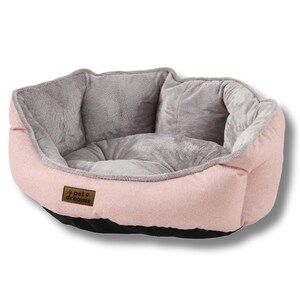 Op de afbeelding: Een roze en grijs huisdierbed met een pluche interieur en een getextureerde buitenkant. Het bed heeft een laag profiel met een zwarte basis en een bruin label met de tekst "pet dreams".