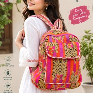 May include: A quilted backpack featuring a vibrant tiger print pattern in shades of orange, pink, and black. The bag has a front pocket with a flap, adjustable shoulder straps, and white stitched detailing along the edges of the fabric panels.