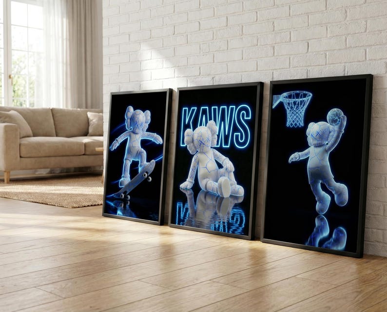 May include: Three framed art prints featuring a blue and white cartoon figure in various poses. One print shows the figure on a skateboard, another with the word "KAWS", and the third with the figure playing basketball. The background is black.