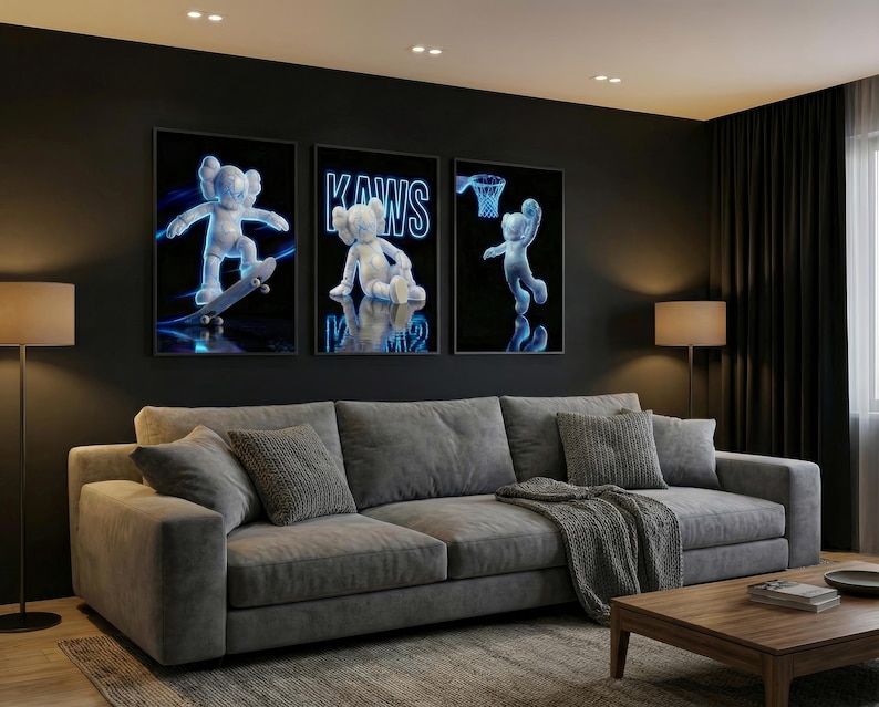 May include: Three framed art prints featuring a white cartoon figure with blue neon outlines. The prints depict the figure skateboarding, sitting, and playing basketball against a black background. The prints are above a gray sofa.