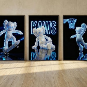 May include: Set of three framed art prints featuring a white cartoon figure with blue neon outlines. One print shows the figure skateboarding, another shows it sitting, and the third shows it playing basketball. The background is black.