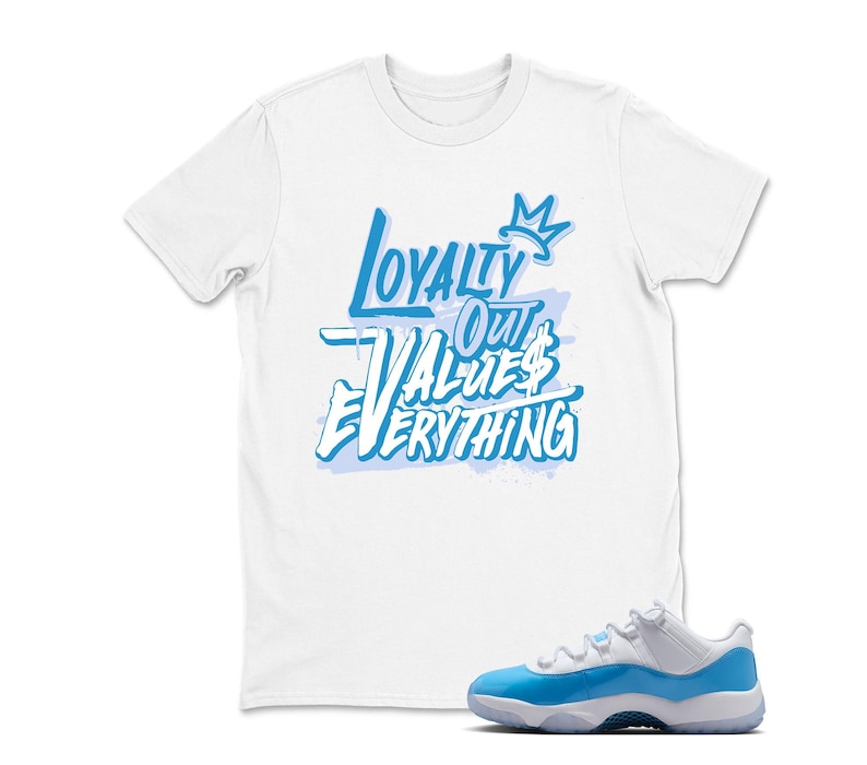 Puede incluir: Camiseta blanca con el texto "Loyalty Out Values Everything" en azul claro. Un par de zapatillas deportivas azules claras y blancas se encuentra en la esquina inferior derecha. Las zapatillas tienen una parte superior blanca y una suela azul claro.