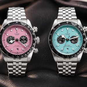 Könnte beinhalten: Zwei Chronographen-Armbanduhren aus Edelstahl mit silbernen Gliederarmbändern. Eine Uhr hat ein rosafarbenes Zifferblatt, die andere ein hellblaues. Beide verfügen über schwarze Tachymeter-Lünetten, drei Hilfszifferblätter und das Tudor Geneve Logo.