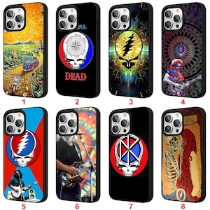 May include: Collection of eight black phone cases with various designs. Designs include a colorful landscape, a skull with a compass, a lightning bolt skull, a musician playing guitar, a Steal Your Face logo, and a skeleton couple.